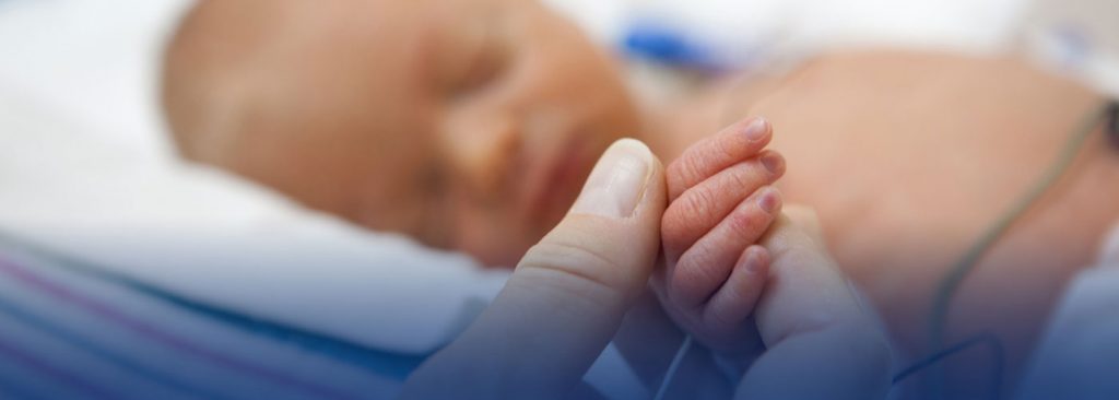 infant hand being held by an adult 