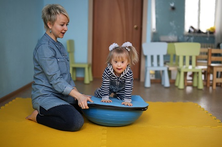 young child on stability ball at therapy